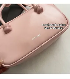 Detail of pink leather handbag with Clear Heart K logo and spherical handle accents