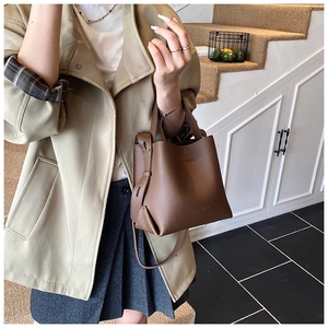 Sac seau en cuir grainé marron avec poignées et bandoulière réglable, vue détaillée style