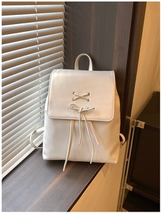 Detailansicht eines weißen Lederrucksacks mit elegantem Schnürbogen und Klappenverschluss