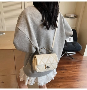 Sac à bandoulière matelassé beige avec poignée en chaîne argentée et fermoir rotatif