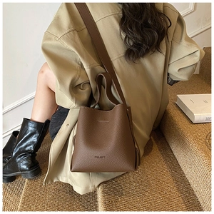 Sac seau en cuir grainé marron avec bandoulière large dans un style moderne