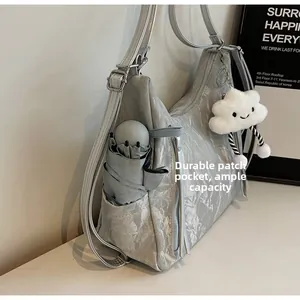 Silver grey handbag detail showing side pocket with umbrella and cloud pendant charm