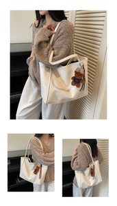 Detail of white leather tote bag with a brown teddy bear charm and soft lychee texture