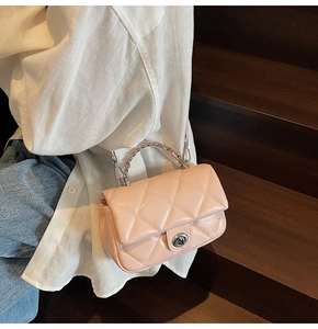 Gros plan du sac à bandoulière matelassé rose avec poignée chaîne et fermoir en métal