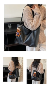 Detail of black faux leather tote bag with a cute brown plush bear charm pendant