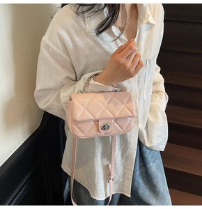 Détail du sac à bandoulière en cuir verni rose clair avec motif matelassé et fermoir