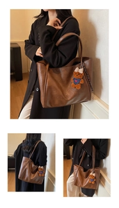 Brown vintage leather tote bag with a cute plush bear charm and long shoulder strap