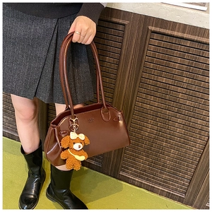 Retro dark brown oily leather shoulder bag with long handles and plush bear charm detail