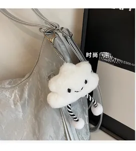Close-up of white plush cloud charm with striped legs on a metallic silver tote bag