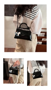 Détails du sac cabas en cuir brillant noir avec charm cheval bleu et boucle métallique