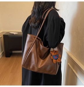 Retro brown large tote bag detail showing high-quality leather texture and bear charm