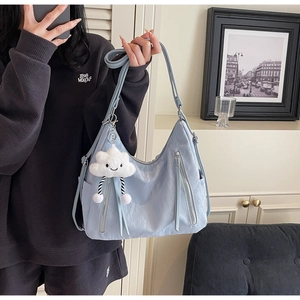 Detail of light blue waterproof nylon shoulder bag with cute cloud plush charm