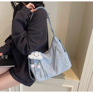 Detail of light blue hobo bag showing nylon texture and plush cloud keychain