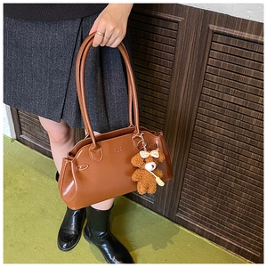 Caramel oil wax leather shoulder bag with logo detail and cute brown bear charm accessory