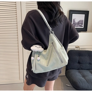Close-up of light green pleated leather crossbody bag with a cute white cloud pendant