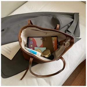 Internal view of brown tote bag showing large capacity for tablet and cosmetics
