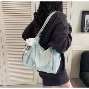 Mint green nylon shoulder bag with vertical zipper pockets and white cloud plush charm