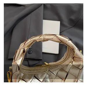 Détail de la poignée tressée confortable et de la texture métallique dorée du sac à main