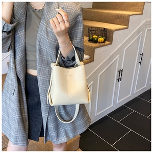 Détail du sac seau en cuir grainé blanc cassé avec poignée et bandoulière réglable