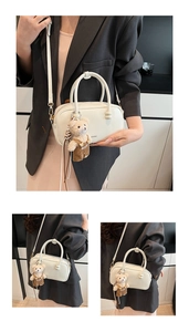 Detail of cream white mini crossbody bag featuring a cute teddy bear plush charm and logo