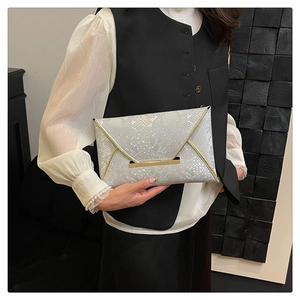 Detail of silver snake-pattern envelope clutch with gold metal trim and buckle closure