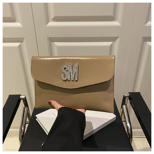 Detailed close-up of khaki envelope clutch with crystal-studded SM metal logo and flap