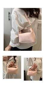 Pink snake-embossed bucket bag showing top handle and adjustable long shoulder strap detail