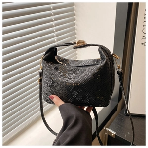 Detailed view of black snake-pattern bucket bag with premium gold-tone metal hardware