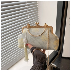 Detail of floral embroidery on vintage handbag with gold metal frame and silk tassel