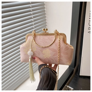 Detailed macro view of pink floral jacquard evening bag with jade tassel and gold chain