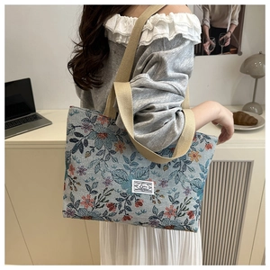 Floral jacquard tote bag with wide straps shown in a minimalist office setting