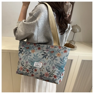 Close-up of vintage floral canvas tote bag with detailed embroidery and cream shoulder strap