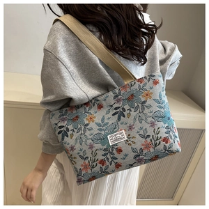 Close-up of vintage floral jacquard tote bag with wide canvas shoulder straps and texture