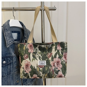 Detail of floral canvas tote bag with woven texture and pink flower patterns on white door