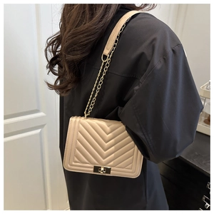 Detail showing beige chevron quilted leather bag with elegant gold chain strap and lock