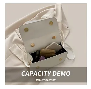 Détail de l'intérieur d'un sac à rabat blanc montrant la capacité pour téléphone et maquillage