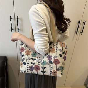 Women's woven tote bag with colorful floral embroidery and canvas shoulder strap