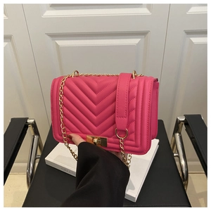 Close-up of rose red V-quilted small square bag with gold metal chain and turn-lock
