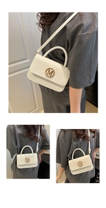 Close-up of woven flap texture and gold M-logo on white leather crossbody handbag