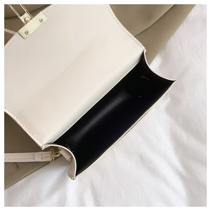 Détail du sac bandoulière en cuir crème avec fermoir doré et compartiment intérieur