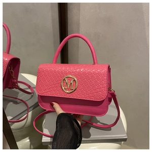 Gros plan sur la texture tissée et boucle dorée d'un sac à main magenta haut de gamme