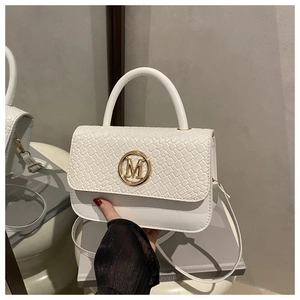 Détail du sac à bandoulière blanc avec rabat tissé et logo métallique M doré