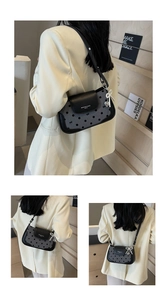 Detailed view of polka dot baguette bag with pearl bow and heart metal pendant