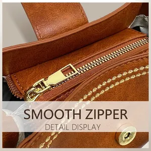 Detail of brown leather bucket bag showing golden zipper, fine stitching, and magnetic buckle