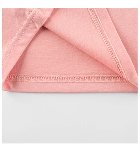 Détail de l'ourlet d'un t-shirt rose montrant une double couture nette et un tissu doux