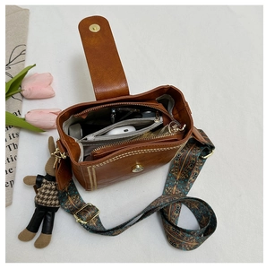 Interior detail of vintage brown bucket bag with ethnic strap and plush charm