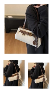 Detail of retro cream shoulder bag showing brown leather straps and gold metal hardware