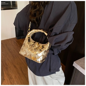 Gros plan du sac hobo tissé doré montrant la texture tressée et la fermeture éclair