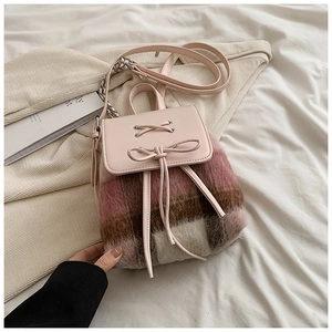 Detail des rosa karierten Plüschrucksacks mit Schleifenakzenten und Goldkette