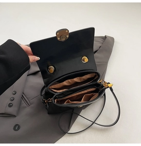Détail de l'intérieur du sac en cuir noir avec deux compartiments et finitions dorées